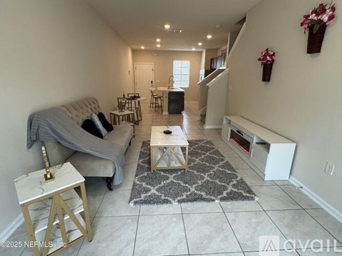 A living room with a grey couch and a white coffee table.