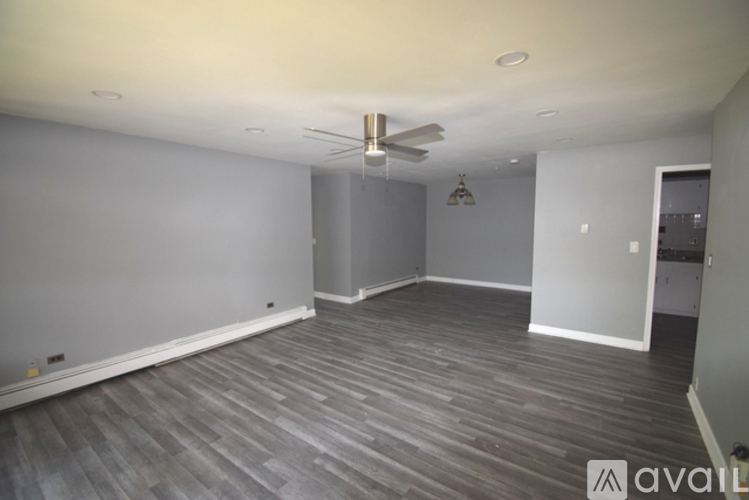 A room with wooden flooring and a ceiling fan.