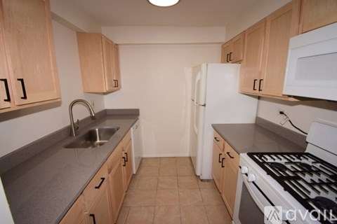 A kitchen with wooden cabinets and a white fridge.