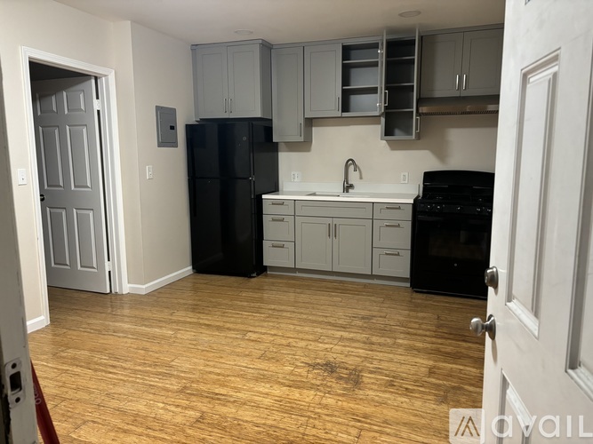 A kitchen with a black fridge and black oven.