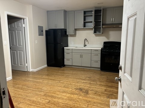 A kitchen with a black fridge and black oven.