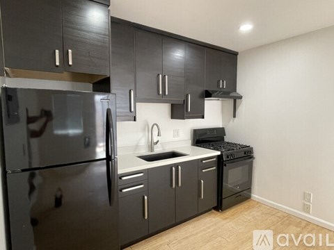 A kitchen with black cabinets and stainless steel appliances.