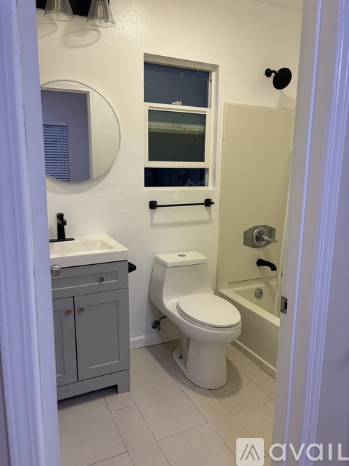 A bathroom with a toilet, sink, and mirror.