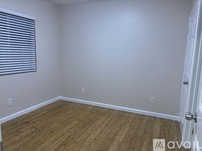 A room with wooden flooring and a white door.
