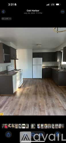 A kitchen with a white refrigerator and wooden flooring.