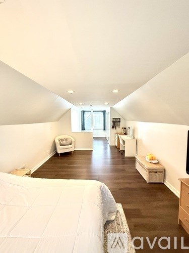 A bedroom with a large bed and a window.