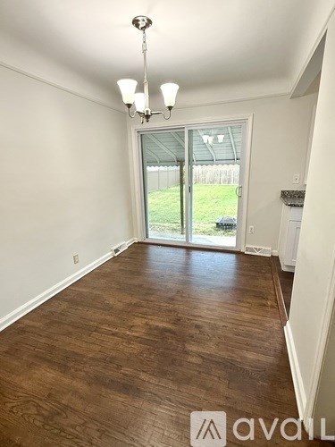 A room with wooden floors and a chandelier.