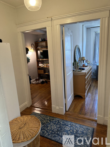A room with a mirror and a dresser is visible through an open door.