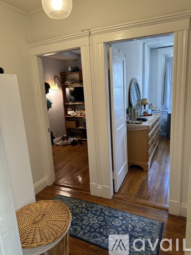 A room with a mirror and a dresser is visible through an open door.