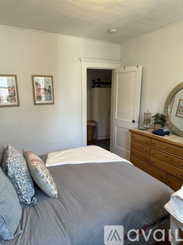 A bedroom with a bed, dresser, and mirror.