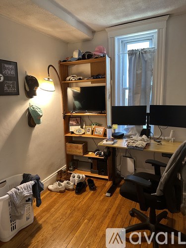 A room with a desk, chair, and a window with curtains.