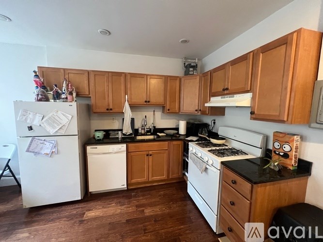 A kitchen with wooden cabinets and a white fridge.