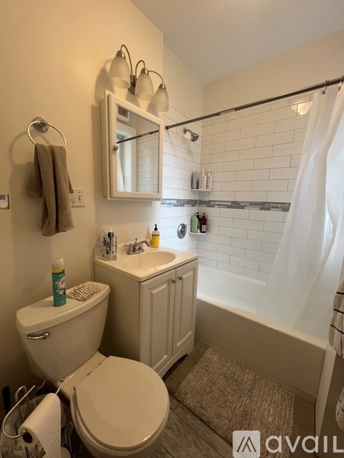 A bathroom with a toilet, sink, and mirror.