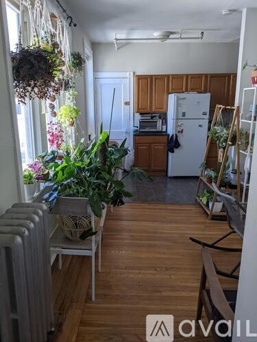 A kitchen with wooden floors and a white refrigerator.