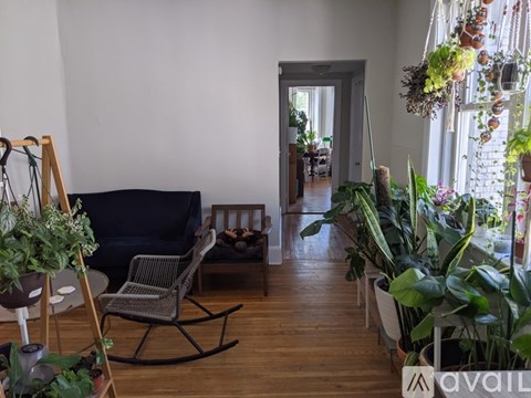 A living room with a black sofa and a wooden rocking chair.