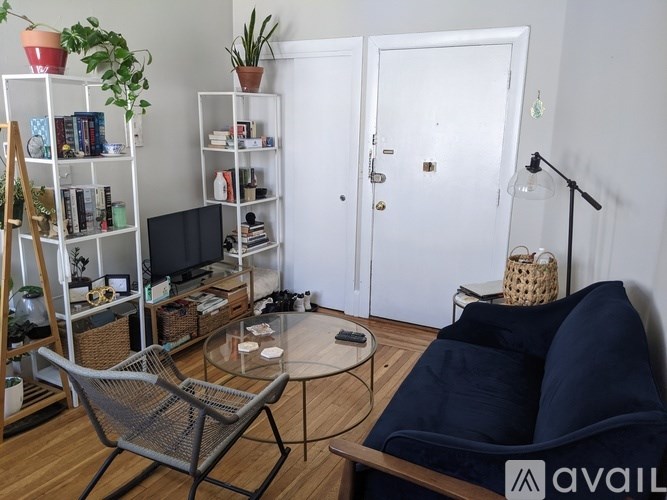 A living room with a sofa, a chair, a coffee table, and a TV.