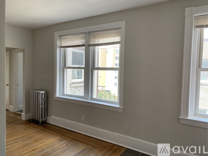 A room with a window and a radiator on the floor.