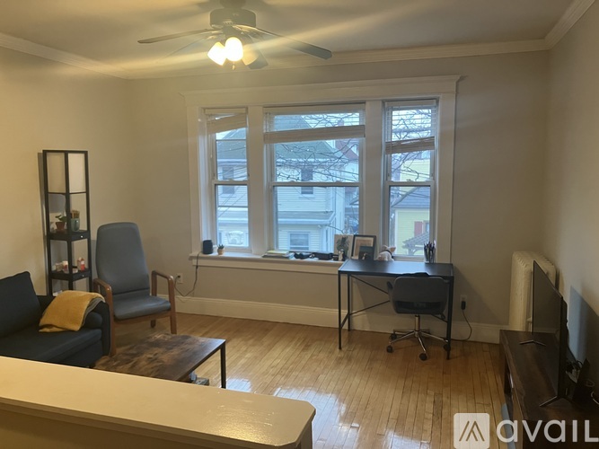 A living room with a couch, chair, and a desk with a computer.