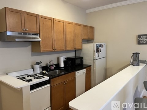 A kitchen with wooden cabinets and a white counter.