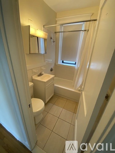 A small white bathroom with a toilet, sink, and bathtub.