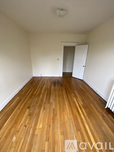 A room with wooden flooring and a white door.