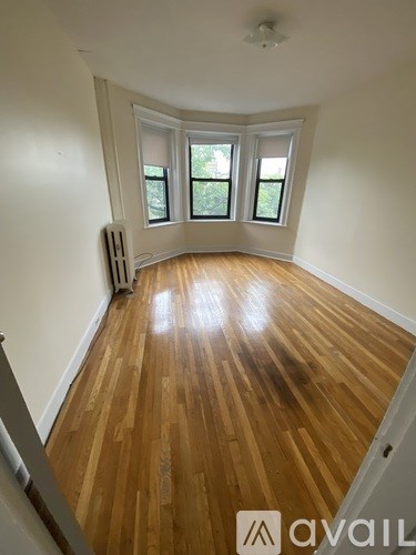 A room with wooden flooring and a window.
