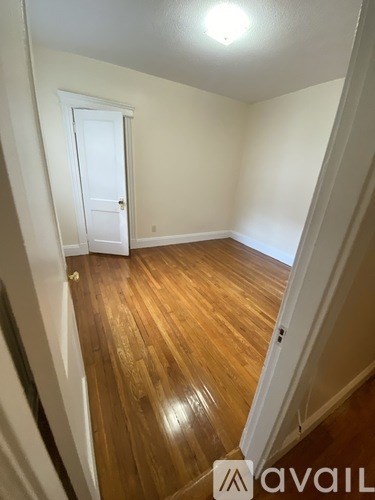 A room with wooden floors and a white door.