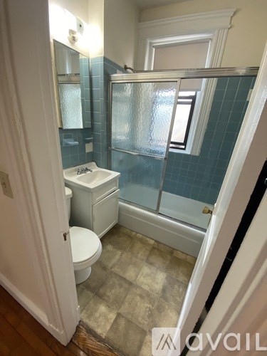 A bathroom with a toilet, sink, and shower.