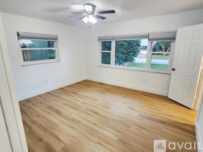 A room with wooden flooring and a ceiling fan.