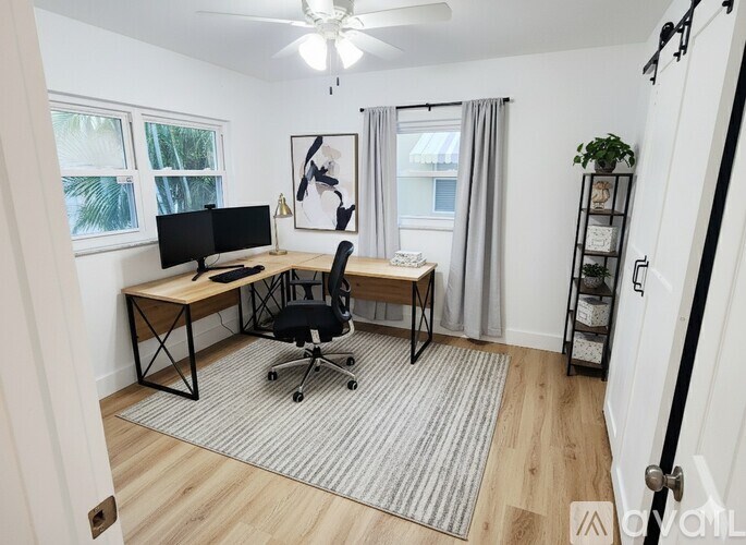 A room with a desk and a chair in front of a window.