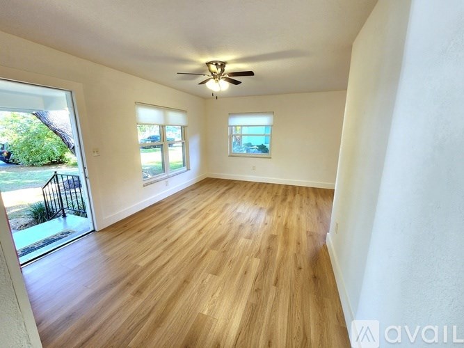 A room with wooden flooring and a ceiling fan.