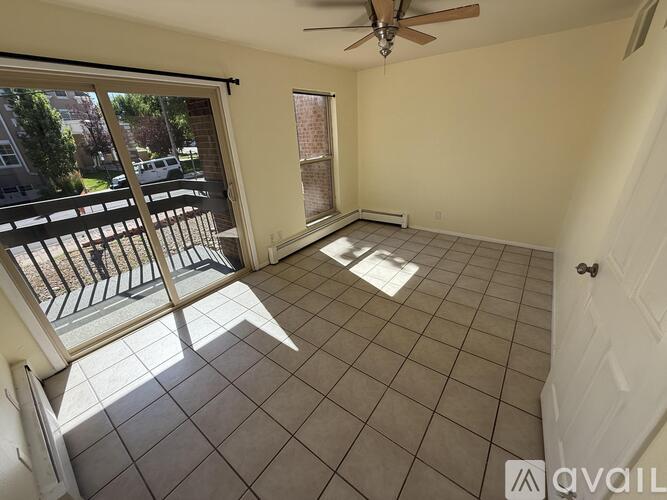 A room with a ceiling fan and tiled flooring.