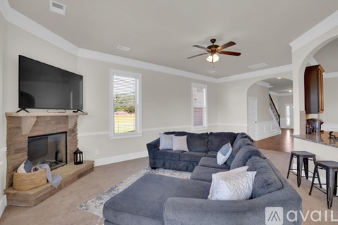 A living room with a grey couch and a fireplace.