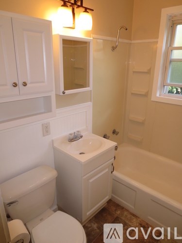 A white bathroom with a toilet, sink and bathtub.