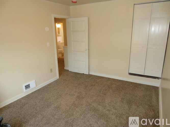 A room with a carpeted floor and a white door.