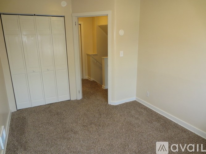 A room with a carpeted floor and a white door.