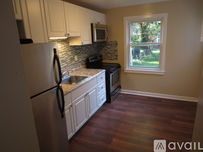 A kitchen with a refrigerator, microwave, and sink.