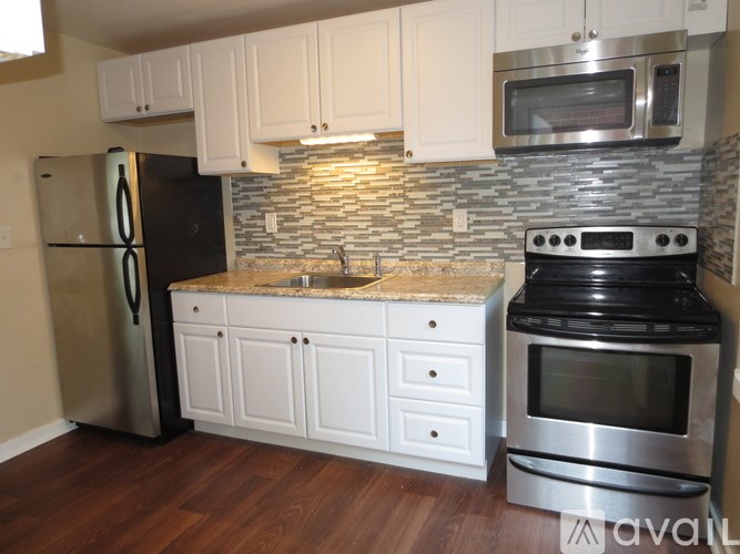 A kitchen with a refrigerator, oven, microwave, and cabinets.