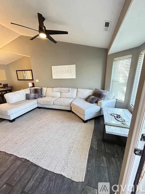 A living room with a white couch and a rug.