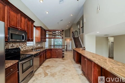 A kitchen with wooden cabinets and a marble countertop.