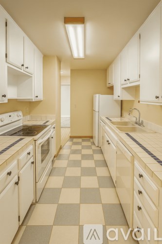 A kitchen with white cabinets and a checkered floor.