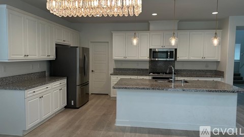A kitchen with white cabinets and a granite countertop.