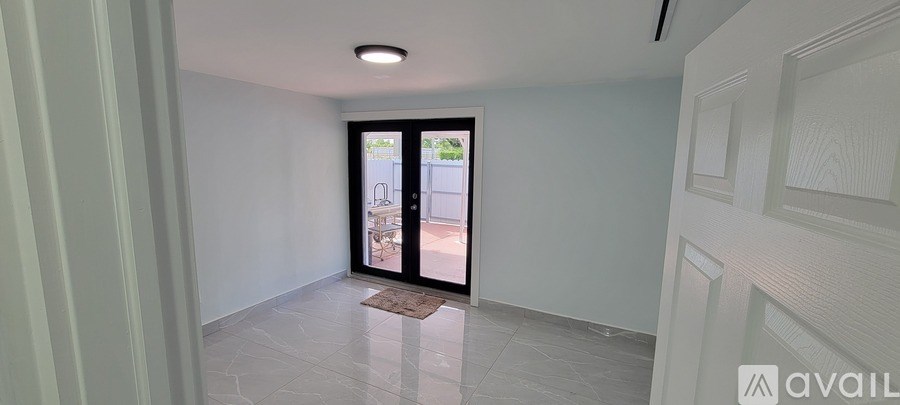 A hallway with a door leading to a balcony.