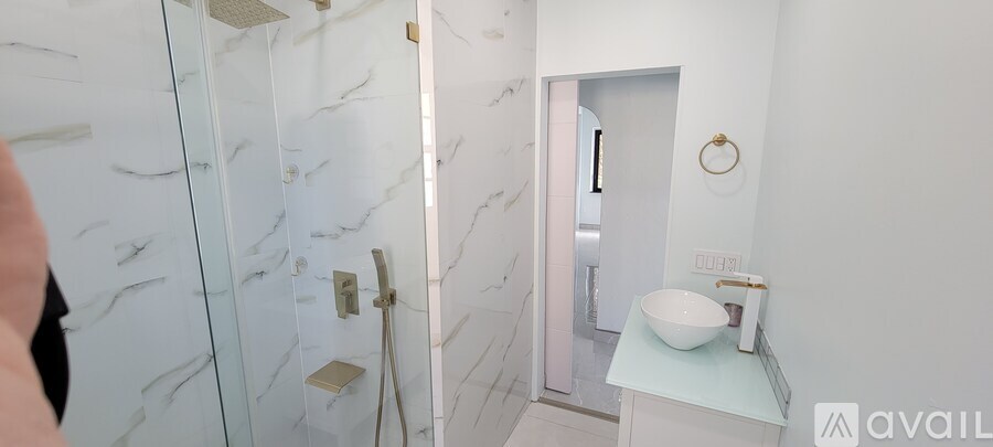 A bathroom with a marble wall and a white sink.