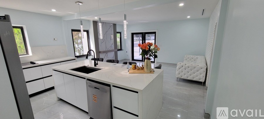 A modern kitchen with a white countertop and a sink.