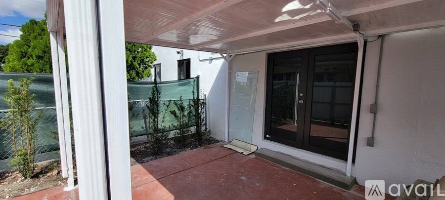 A patio area with a glass door and a white column.