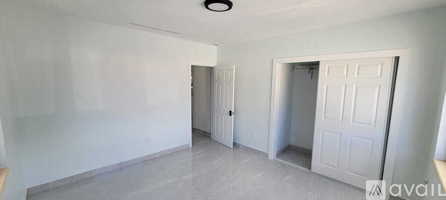 A room with a white door and a white wall.