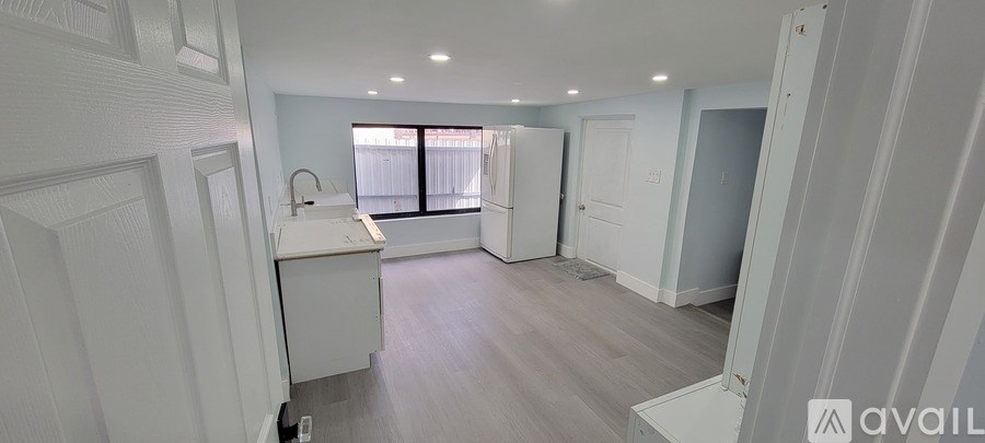 A white kitchen with a sink and a window.