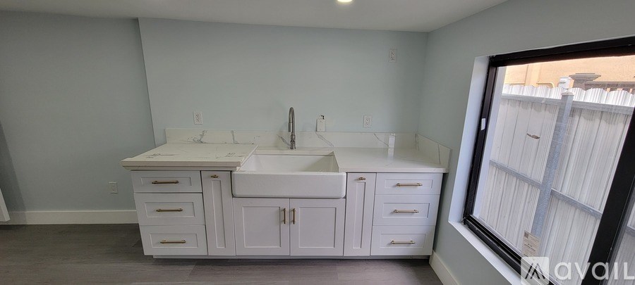 A white bathroom vanity with a sink and a mirror.
