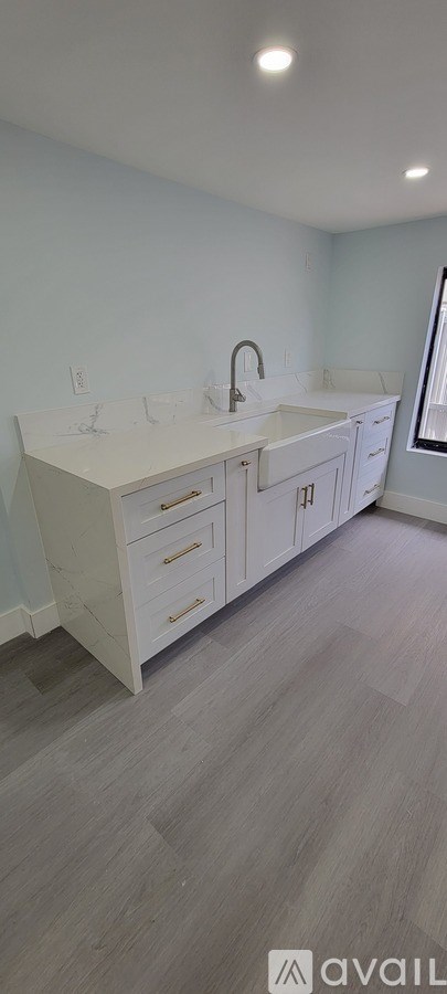 A spacious room with a doorway leading to another room.